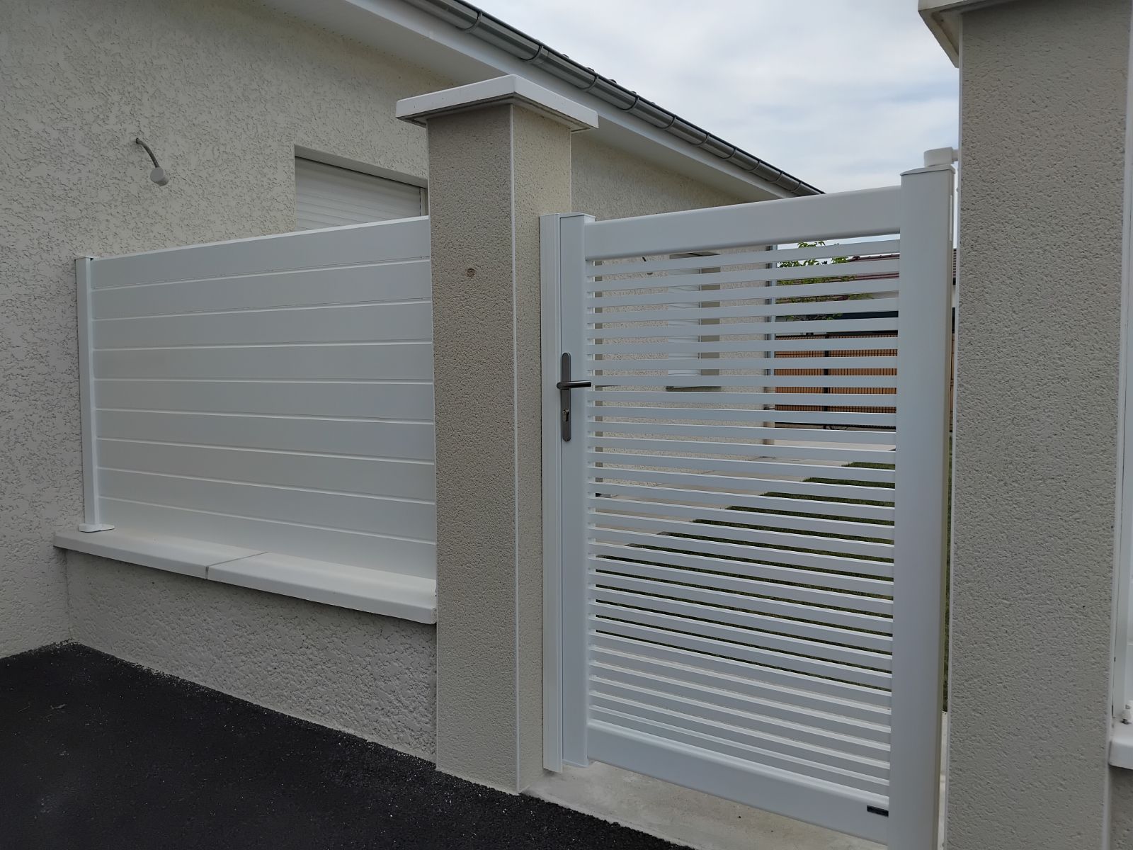 Claustra et portillon blancs en aluminium sur un muret